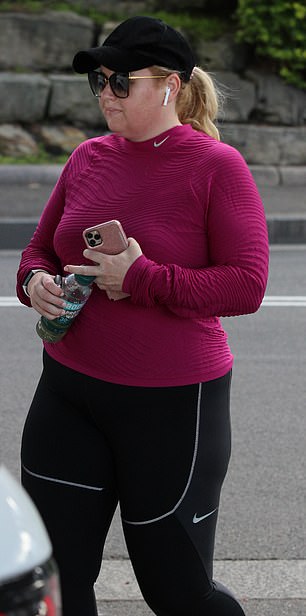 Serious business: Rebel looked committed to the walk with her barely cracking a smile as she listened to music and got in her exercise for the day