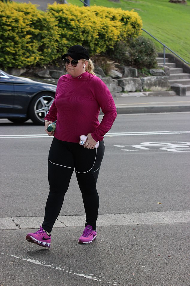 Serious business: Rebel looked committed to the walk with her barely cracking a smile as she listened to music and got in her exercise for the day